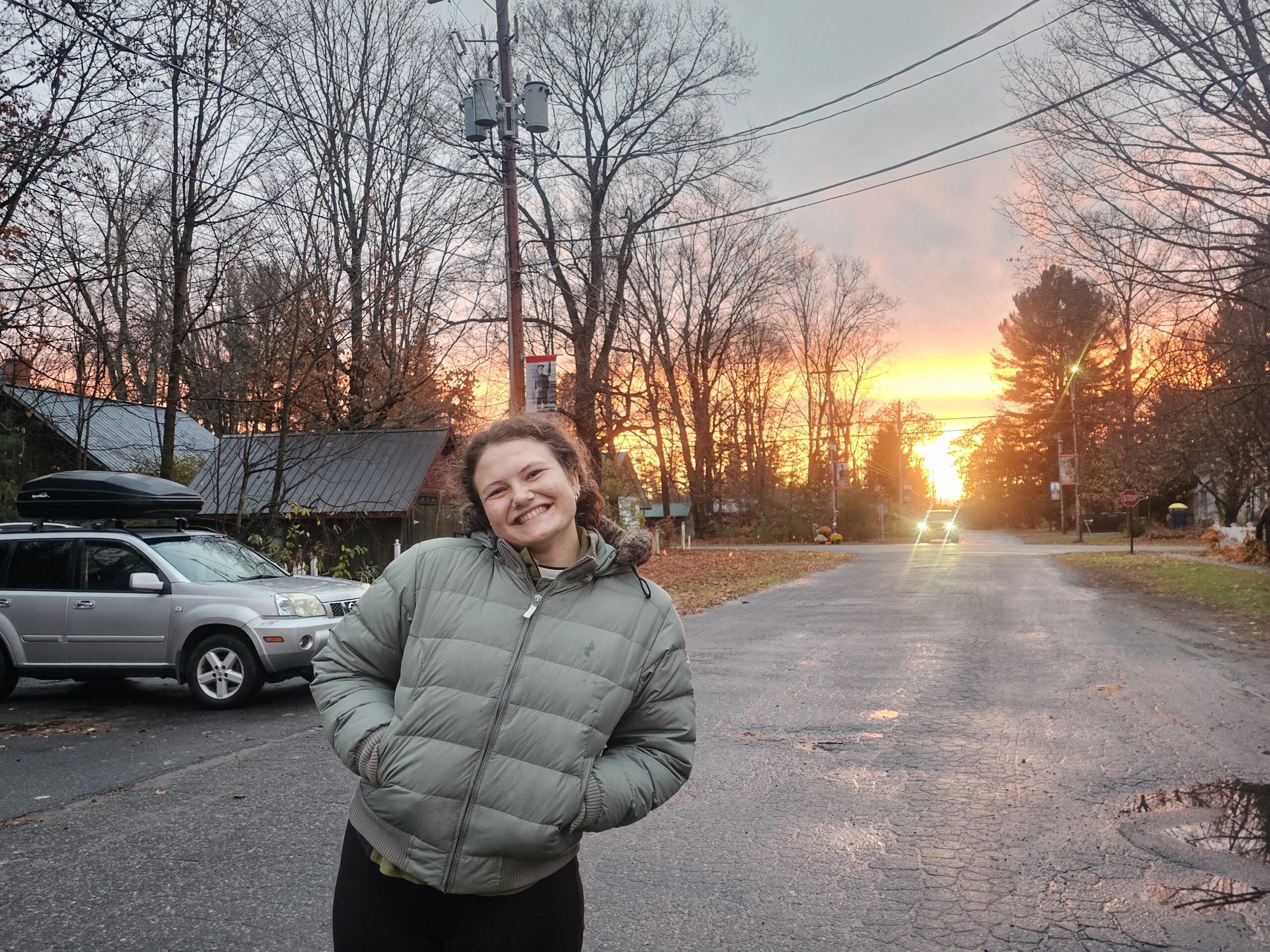 Alex Miers, the Summer Spiritual Development Manager at Muskoka Woods, poses in a winter jacket on a road.